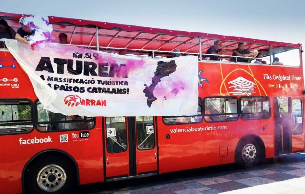 Miembros de Arran lanzan dos botes de humo en un autobús turístico en València