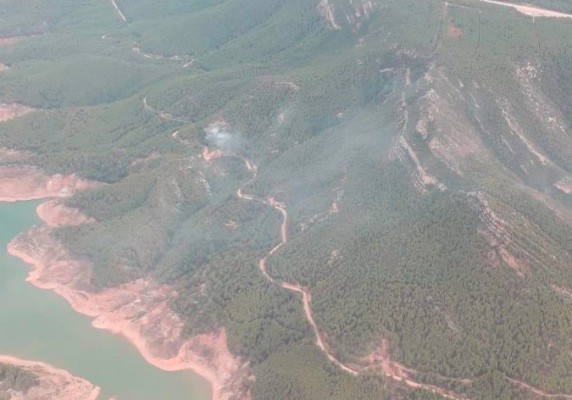 Cuatro medios aéreos trabajan en la extinción de un fuego forestal cerca del embalse de Benagéber
