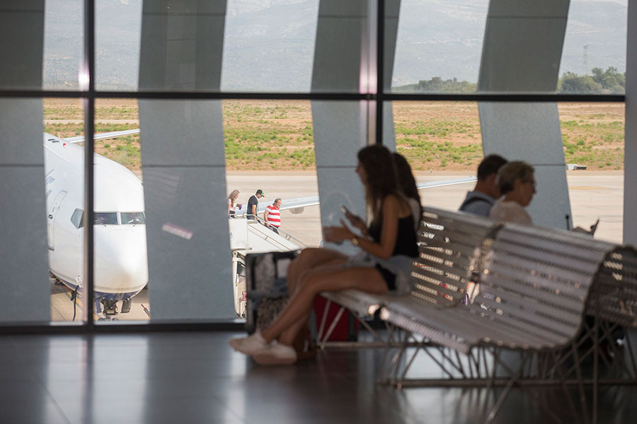 Varios pasajeros esperan en el aeropuerto de Castellón a que se vacíe el avión para poder subir a él. - 