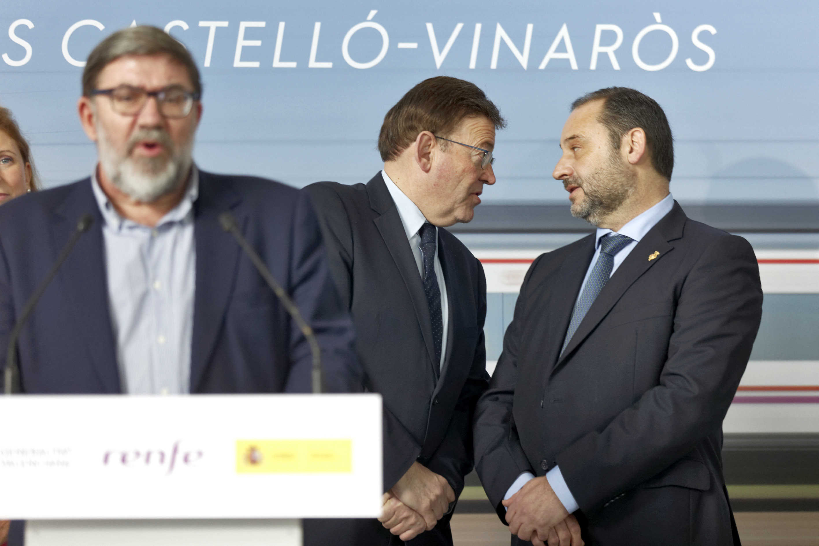 Ximo Puig y José Luis Ábalos dialogan mientras interviene Enric Pla en el acto por los Cercanías a Vinaròs. (Foto: ANTONIO PRADAS) - 