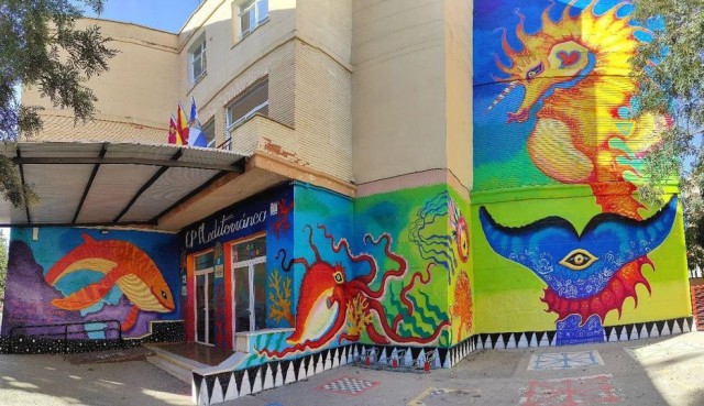 El artista aguileño Javier Espinosa pinta sus criaturas marinas en el CP Mediterraneo, su colegio