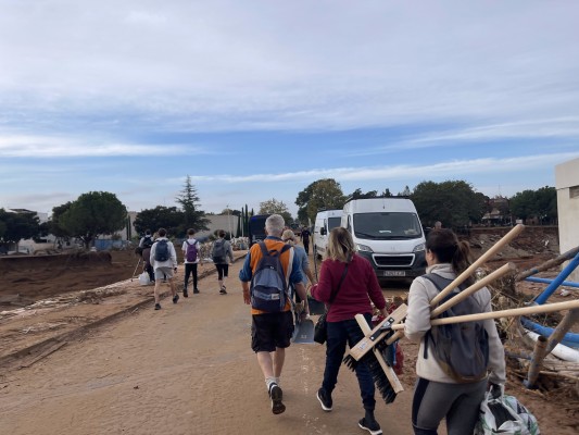 Un río incesante de gente con cubos, escobas y agua sale a pie de Valencia para ayudar
