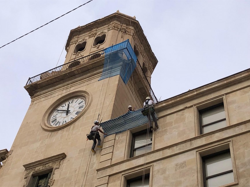 Los trabajos de instalación de la malla protectora sobre la torre del reloj. - 