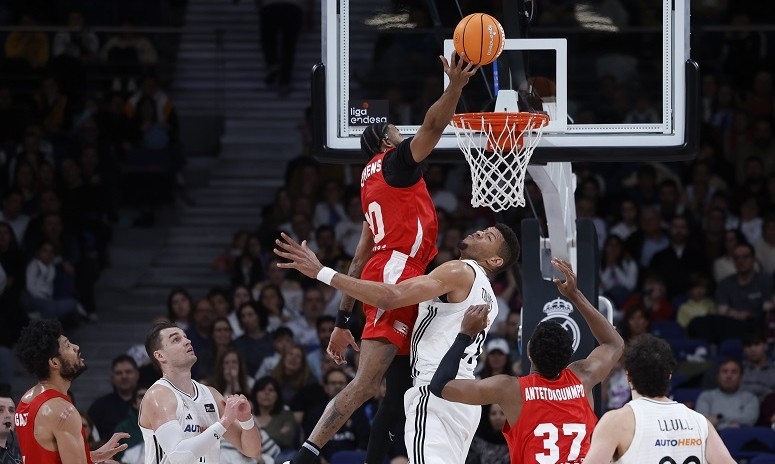 DJ Stephens yendo por el mate y Kostas Antetokounmpo de espaldas en el Real Madrid-UCAM CB. - Foto: ACB PHOTO