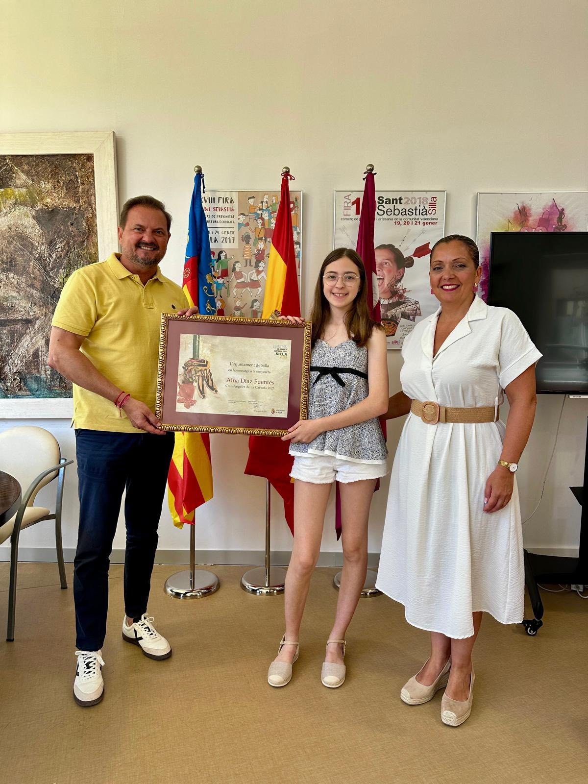 Vicente Zaragozá i Trini Martínez reben a Aina Díaz Fuentes. - Foto: AJUNTAMENT DE SILLA Vicente Zaragozá i Trini Martínez reben a Aina Díaz Fuentes.