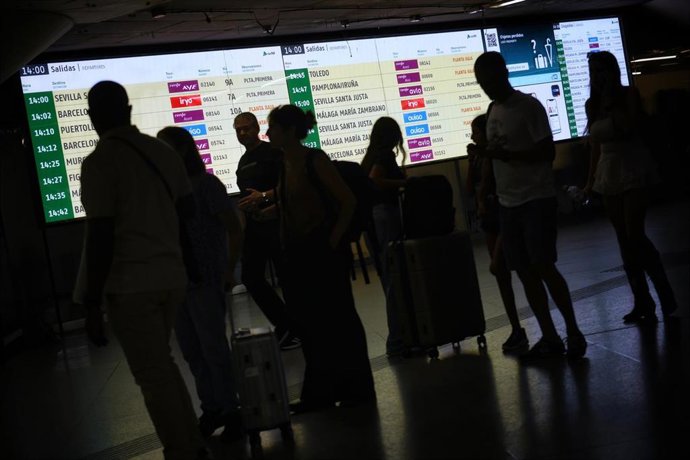 Varias personas observan las pantallas informativas en  la Estación de Madrid - Puerta de Atocha - Almudena Grandes. a 4 de septiembre de 2025, en Madrid (España). - 