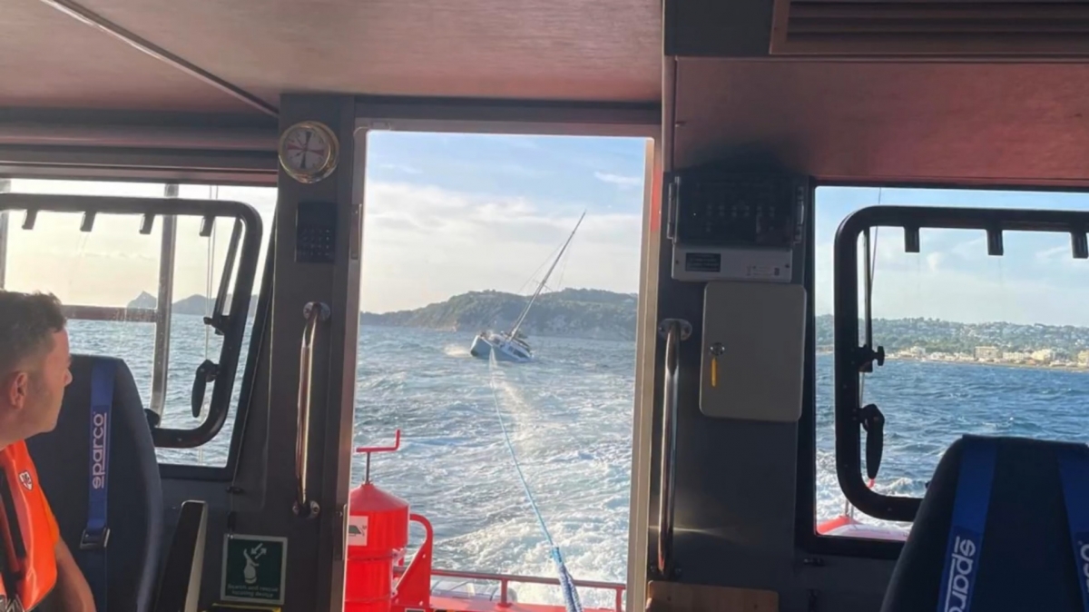 Remolcan un catamarán encallado por el mal tiempo en Xàbia con dos tripulantes y un perro a bordo