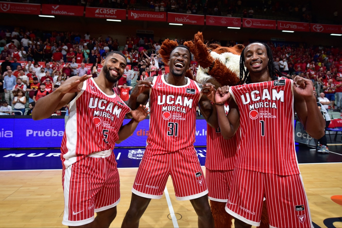 David DeJulius, Dylan Ennis y Michael Forrest, del UCAM CB, con la mascota Vulpi. - Foto: JAVIER BERNAL IMQUALITY