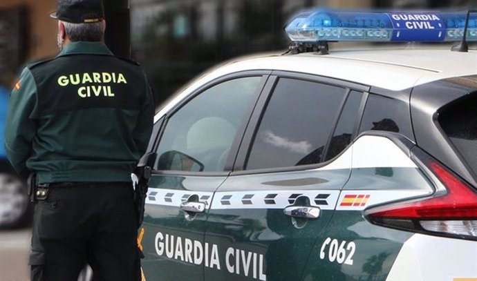 Un agente de la Guardia Civil junto a un vehículo oficial.  Imagen de archivo. - 