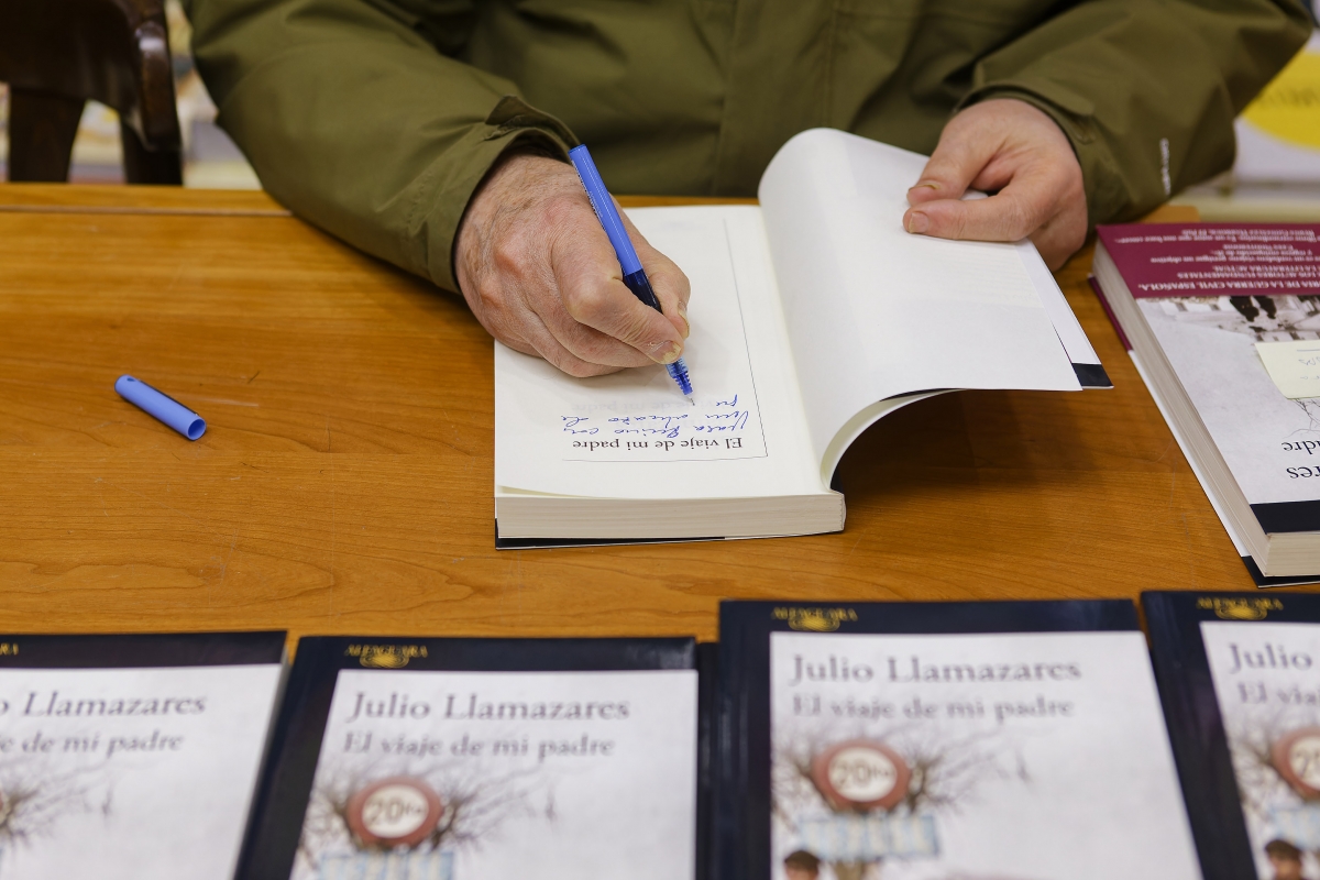 El escritor firma un ejemplar de su última obra. - El escritor firma un ejemplar de su última obra.