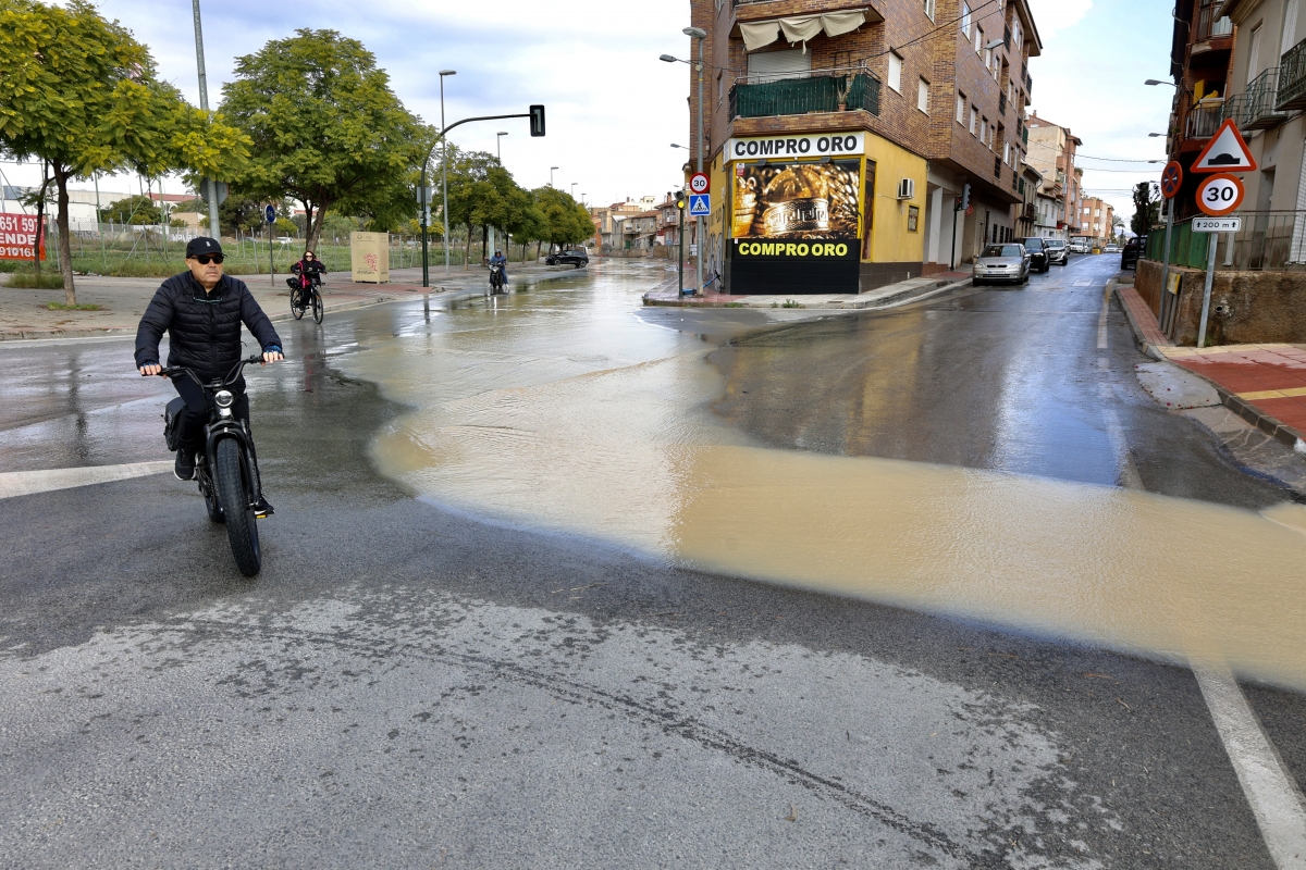Residentes circulan cerca de una zona inundada en la población murciana de Cabezo de Torres..