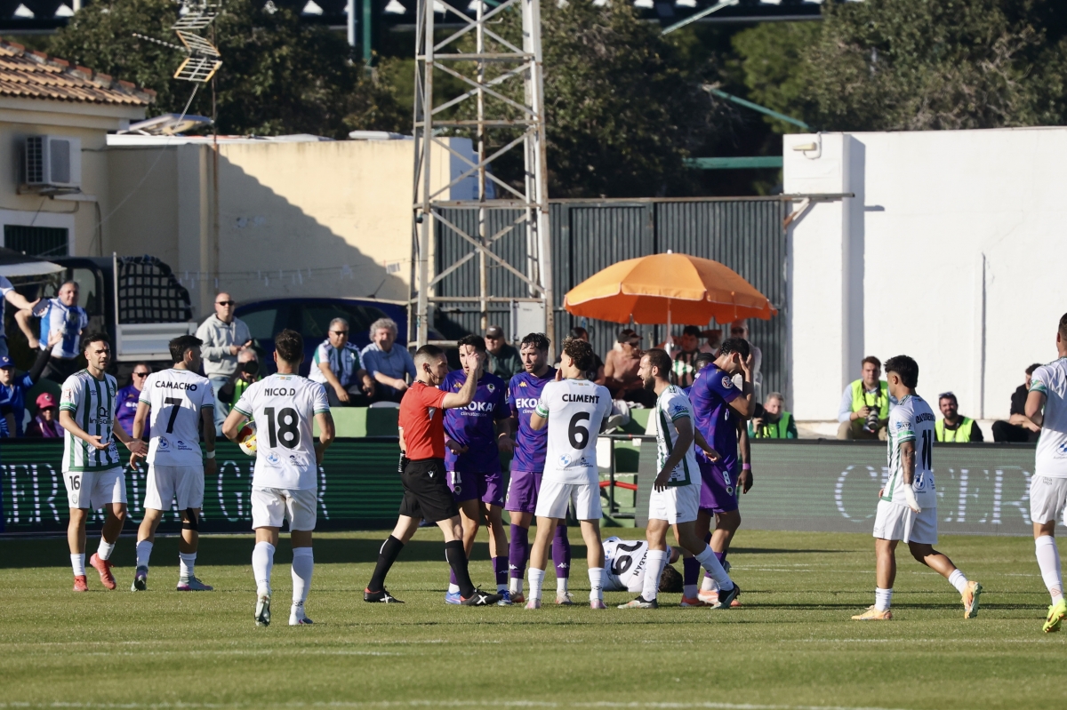 Los jugadores de ambos conjuntos rodean al árbitro