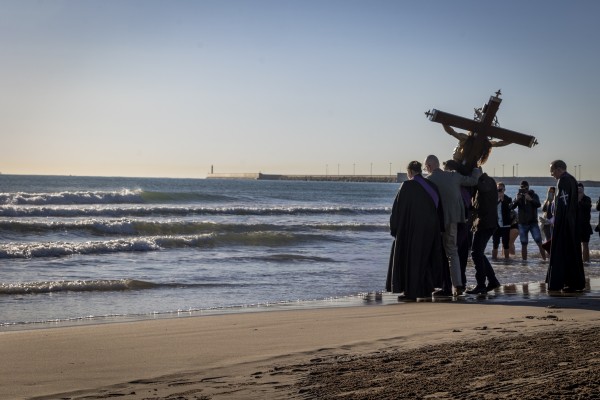 La Semana Santa Marinera de València reza en la playa por los difuntos ante sus Cristos