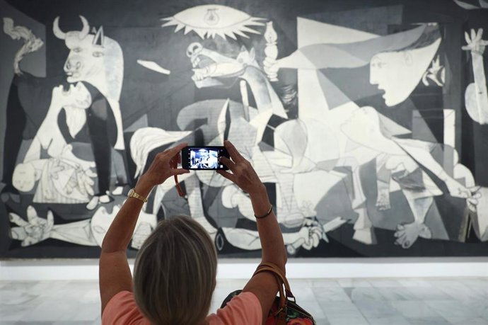Archivo - Una mujer fotografía la obra de Picasso 'Guernica' durante la presentación de los actos conmemorativos del Año Picasso, en el Museo Reina Sofía, a 12 de septiembre de 2022, en Madrid (España).