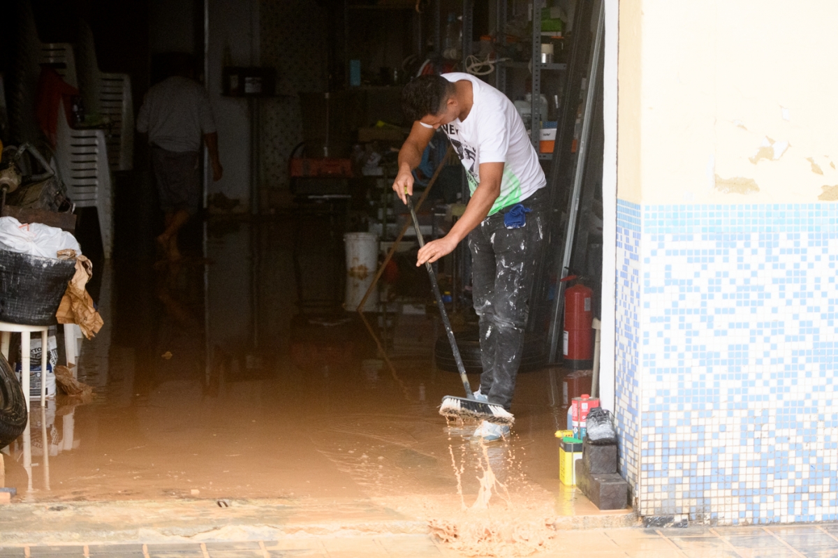 Un hombre realiza labores de achique de agua en su vivienda de Xirivella.