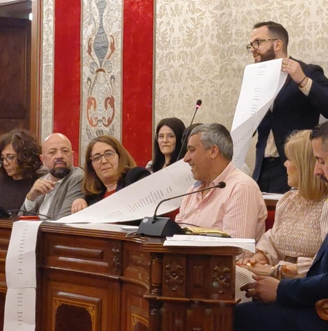 El portavoz de Compromís, Rafa Mas, muestra la lista de ciudades en las que se ha implantado una tasa turística.