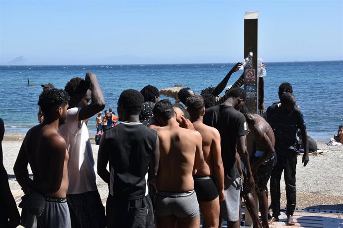 Varias personas se asean en las duchas públicas, en la playa del Trampolín, a 5 de agosto de 2026, en Ceuta (España).