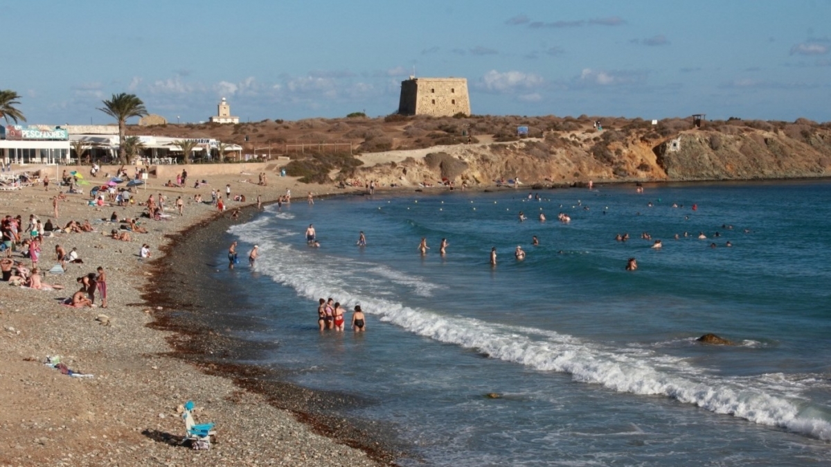 Bañistas en la playa del puerto, con la Torre de San José y el faro de Tabarca al fondo - FOTO: María Cecilia Casal Bañistas en la playa del puerto, con la Torre de San José y el faro de Tabarca al fondo