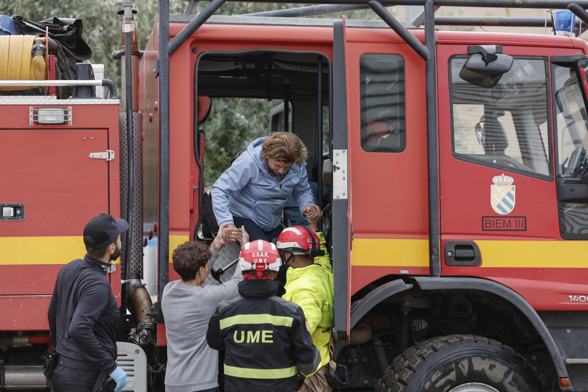 Personal de la UME ayuda a una mujer rescatada en Oliva.