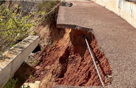 Pavimento de hormigón aparentemente descalzado y conducción expuesta bajo su superficie. - Foto: Grupo de vecinos de Cabo de Palos. Pavimento de hormigón aparentemente descalzado y conducción expuesta bajo su superficie.
