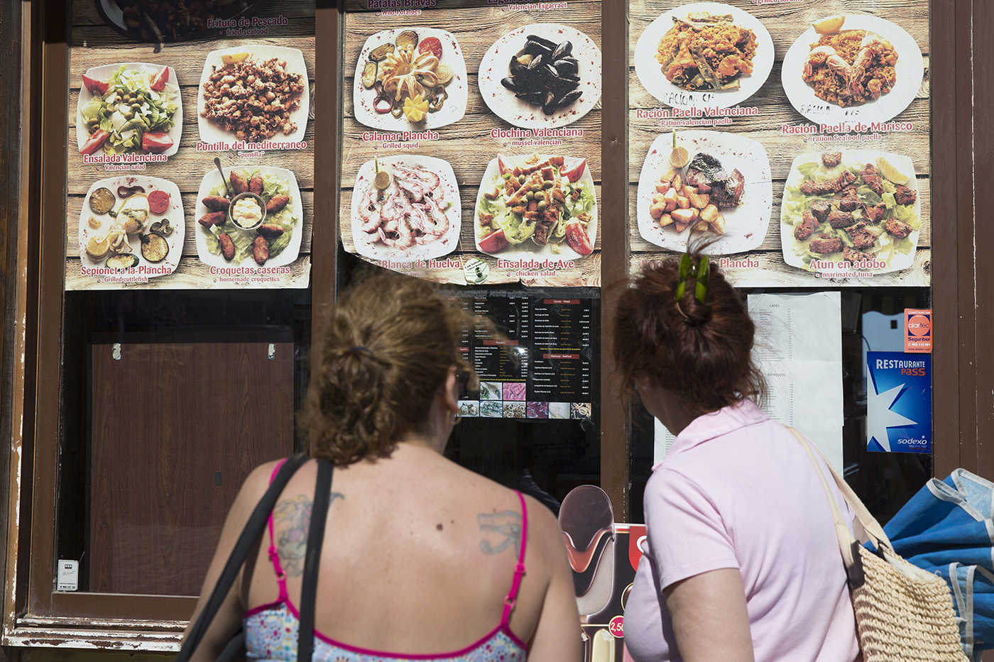 Dos turistas, ante el cartel de un chiringuito (MARGA FERRER) - 