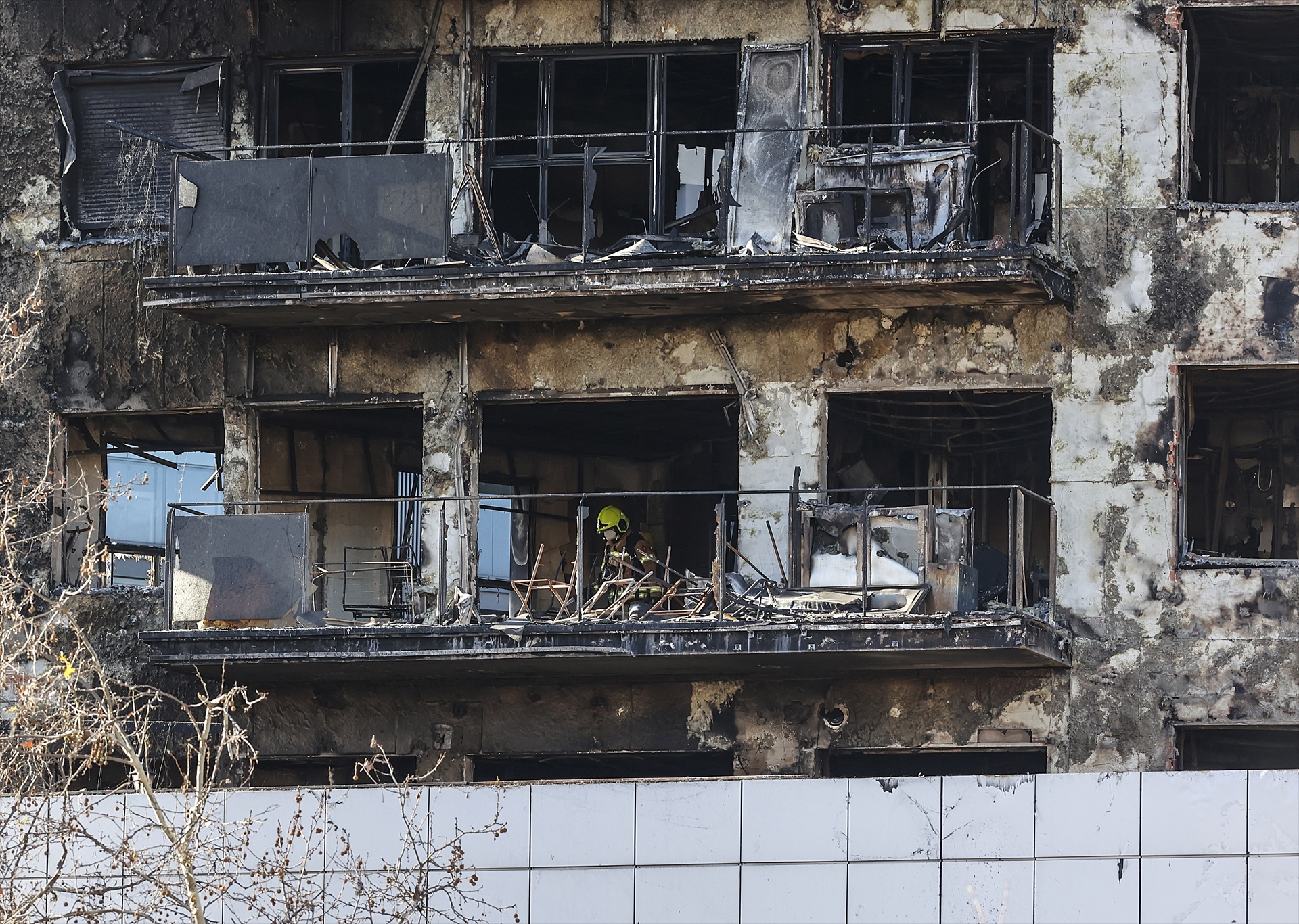 Un agente de la Policía Científica busca las causas del incendio en Campanar. Foto: ROBER SOLSONA/EP - 