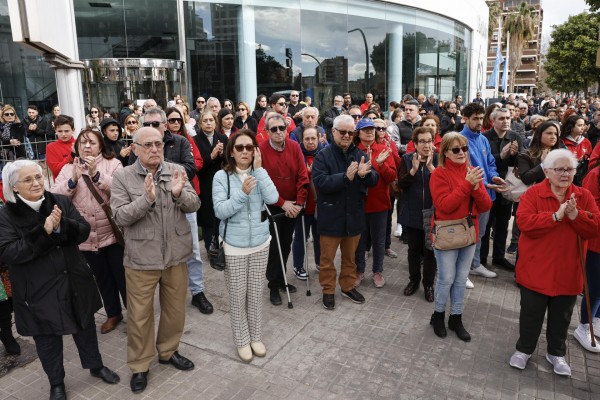 Varios centenares de personas guardan un minuto de silencio ante el edificio incendiado
