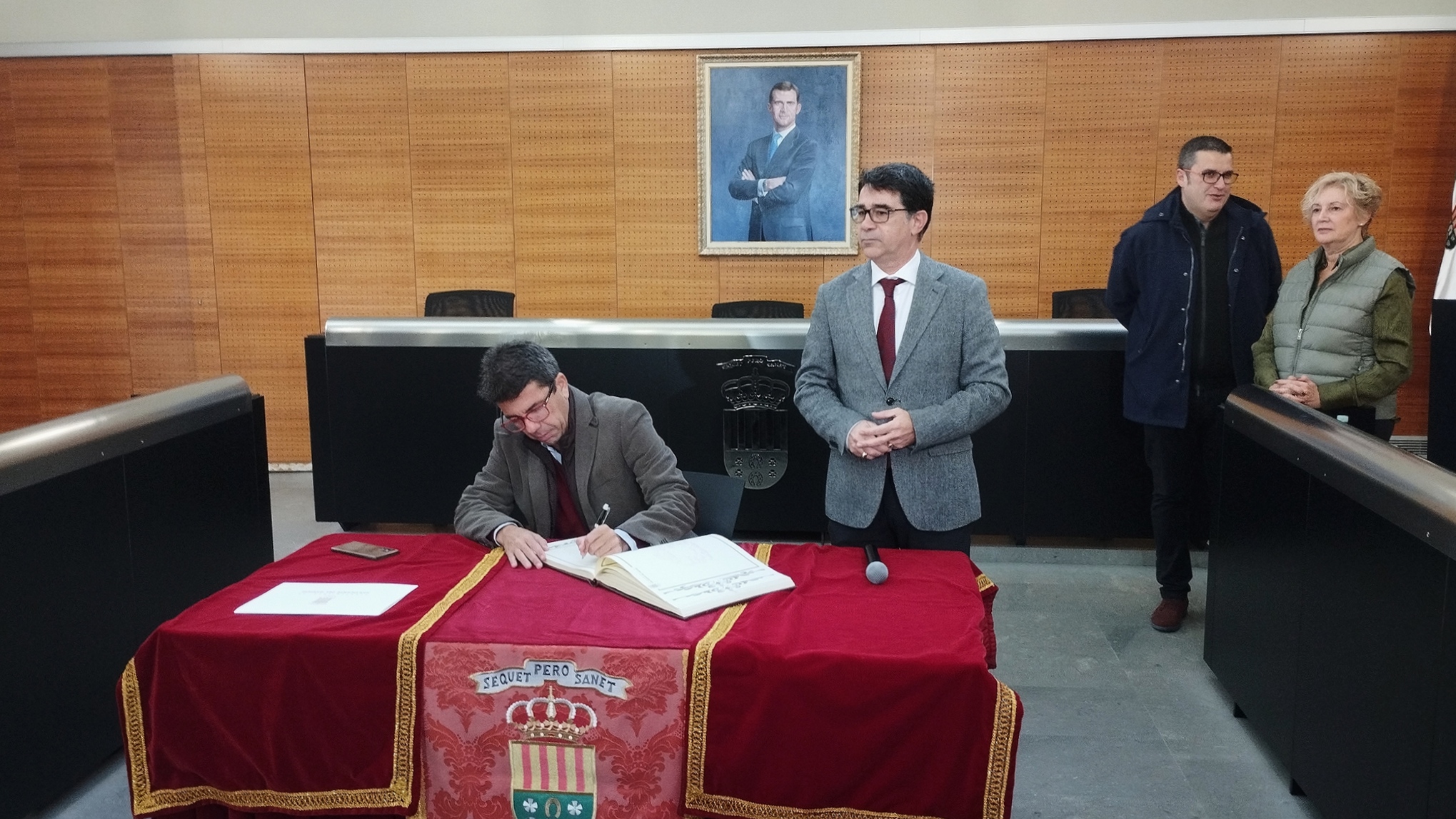 El president de la Generalitat, Carlos Mazón, firmando en el libro del ayuntamiento de San Vicente; detrás, Pachi Pascual, alcalde - 