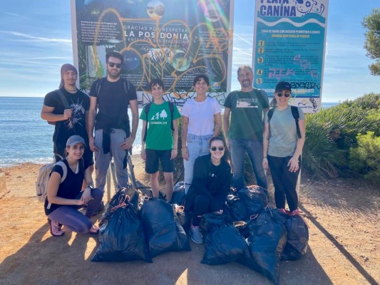 La asociación Enredadera Jove limpia de basura y desechos la playa de la Renegà