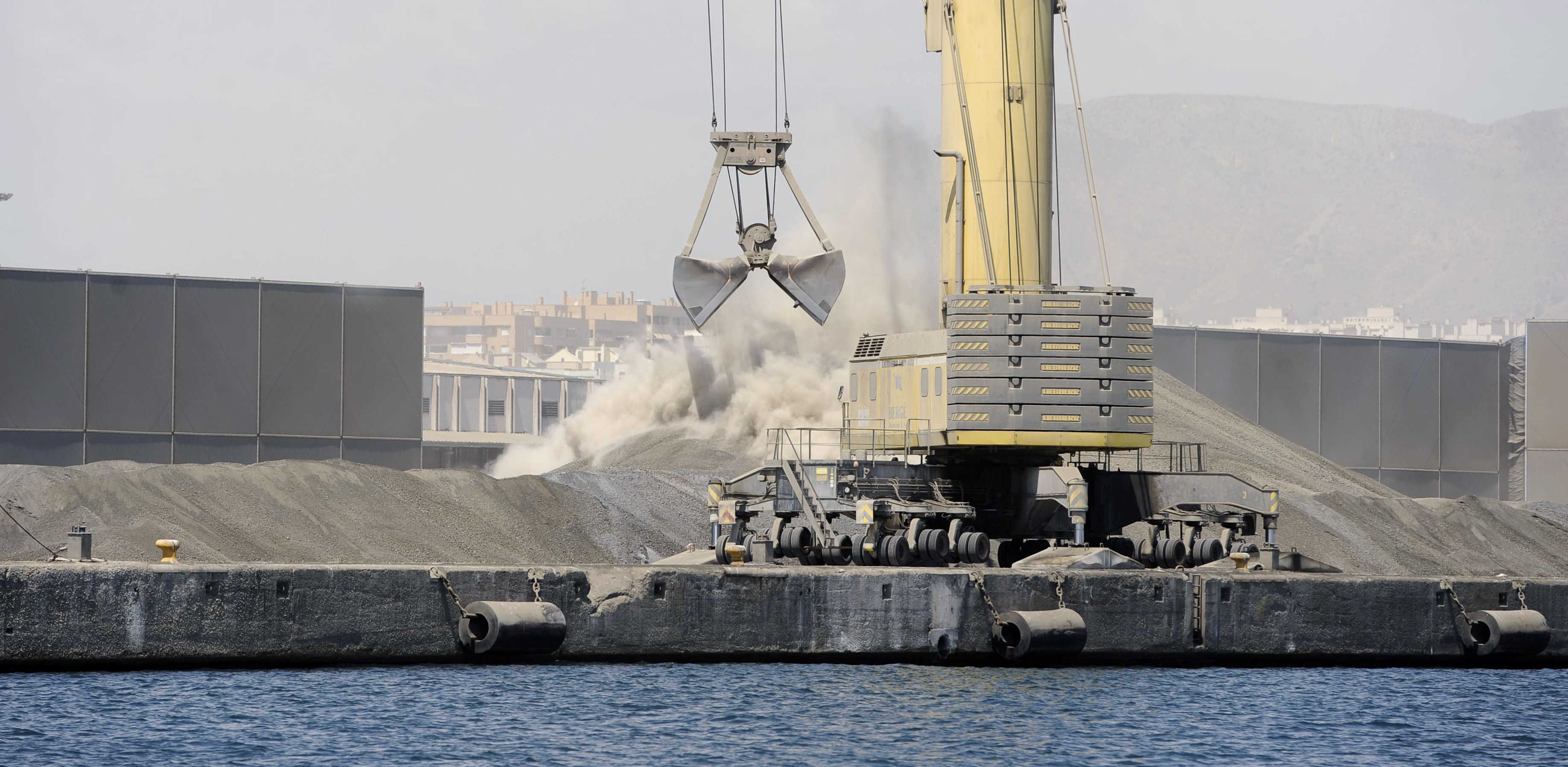 Una grúa en plena descarga de materiales en  el dique de Poniente del Puerto de Levante. Foto: RAFA MOLINA - 