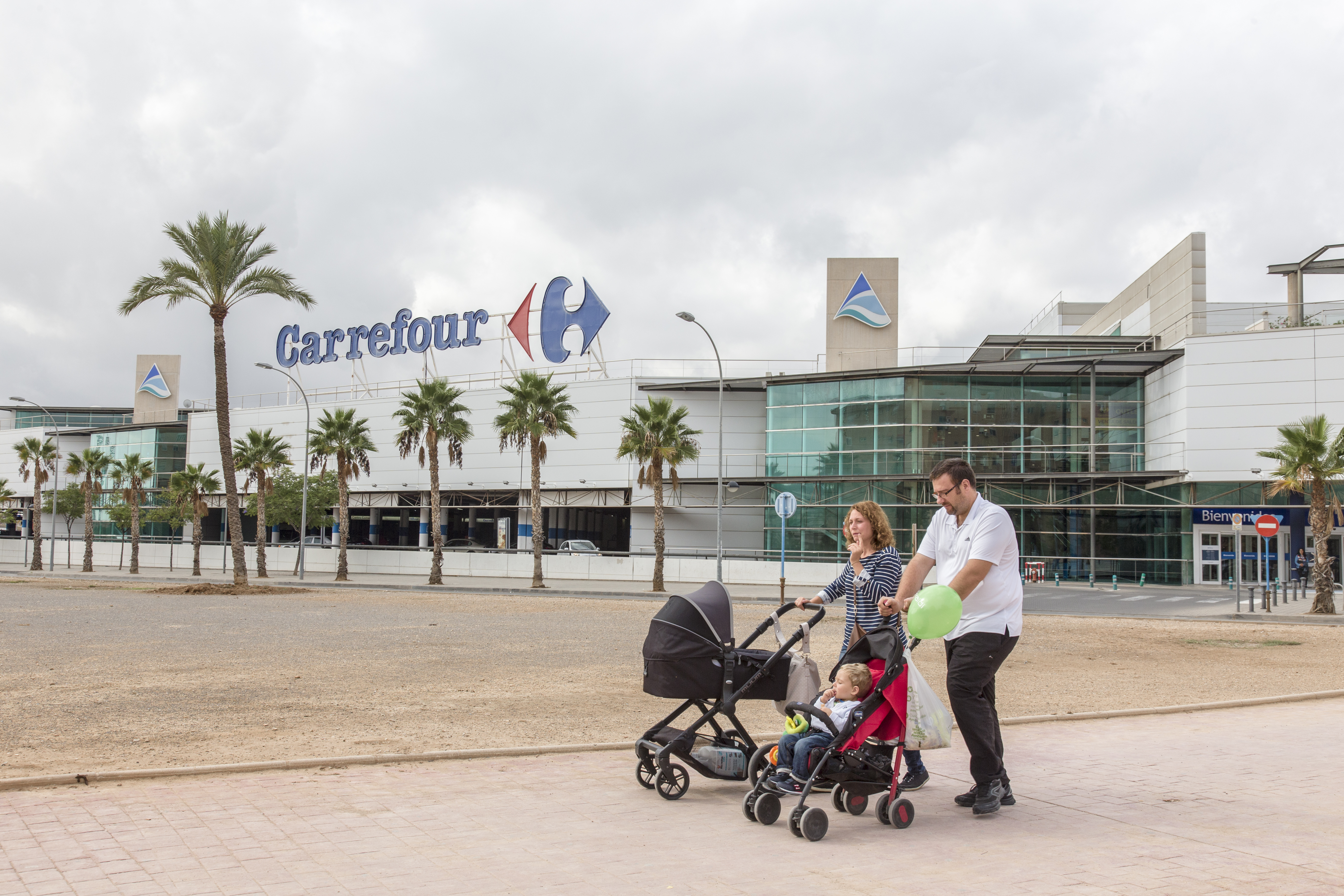 Una familia pasea ante las puertas del centro comercial Puerta de Alicante. Foto: RAFA MOLINA - 
