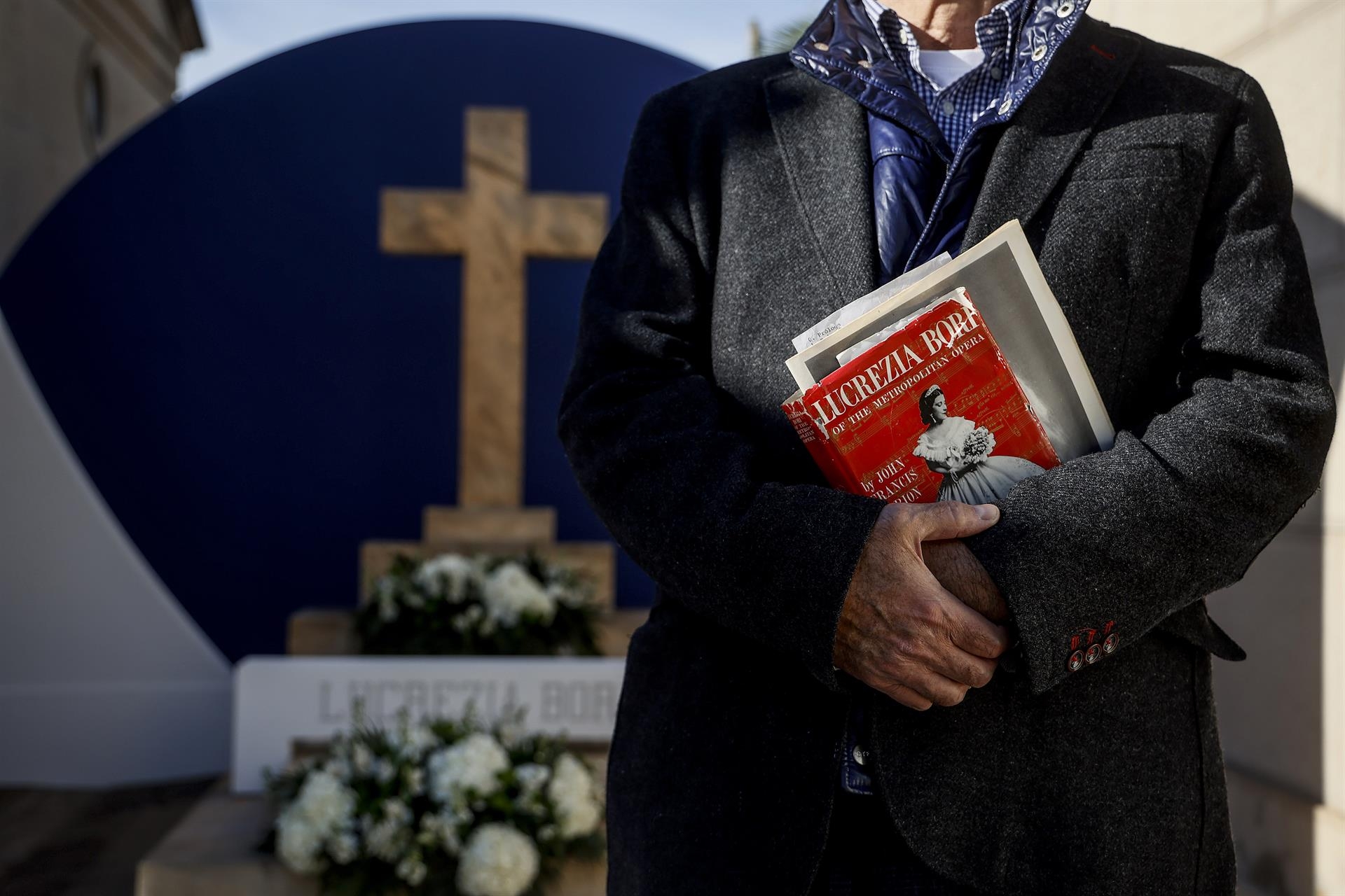 Un hombre sostiene un libro sobre la soprano valenciana Lucrezia Bori, durante su homenaje en la entrada del Cementerio Municipal de Valencia. Foto: Rober Solsona/ Europa Press  - 