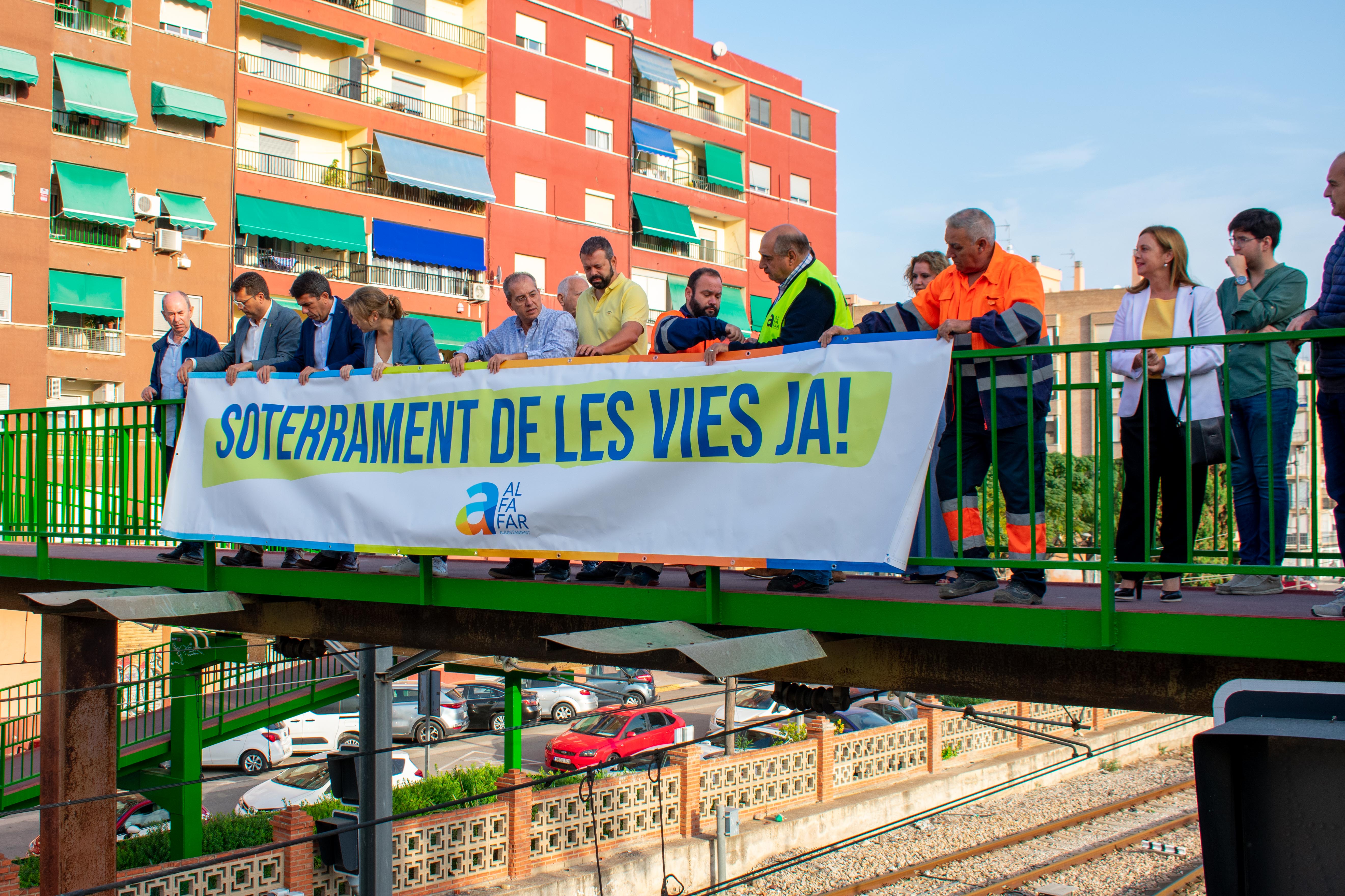 El presidente del PP en la Comunitat Valenciana, Carlos Mazón, colgando el cartel reivindicativo con la corporación municipal. Foto: Ajuntament d'Alfafar - 