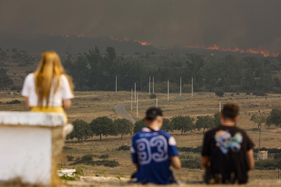 Varias personas observan las llamas del incendio en Bejís desde El Toro. Foto: ROBER SOLSONA/EP - 