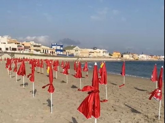 La playa de Levante de Cabo de Palos amanece con cerca de 300 sombrillas de regalo para los bañistas