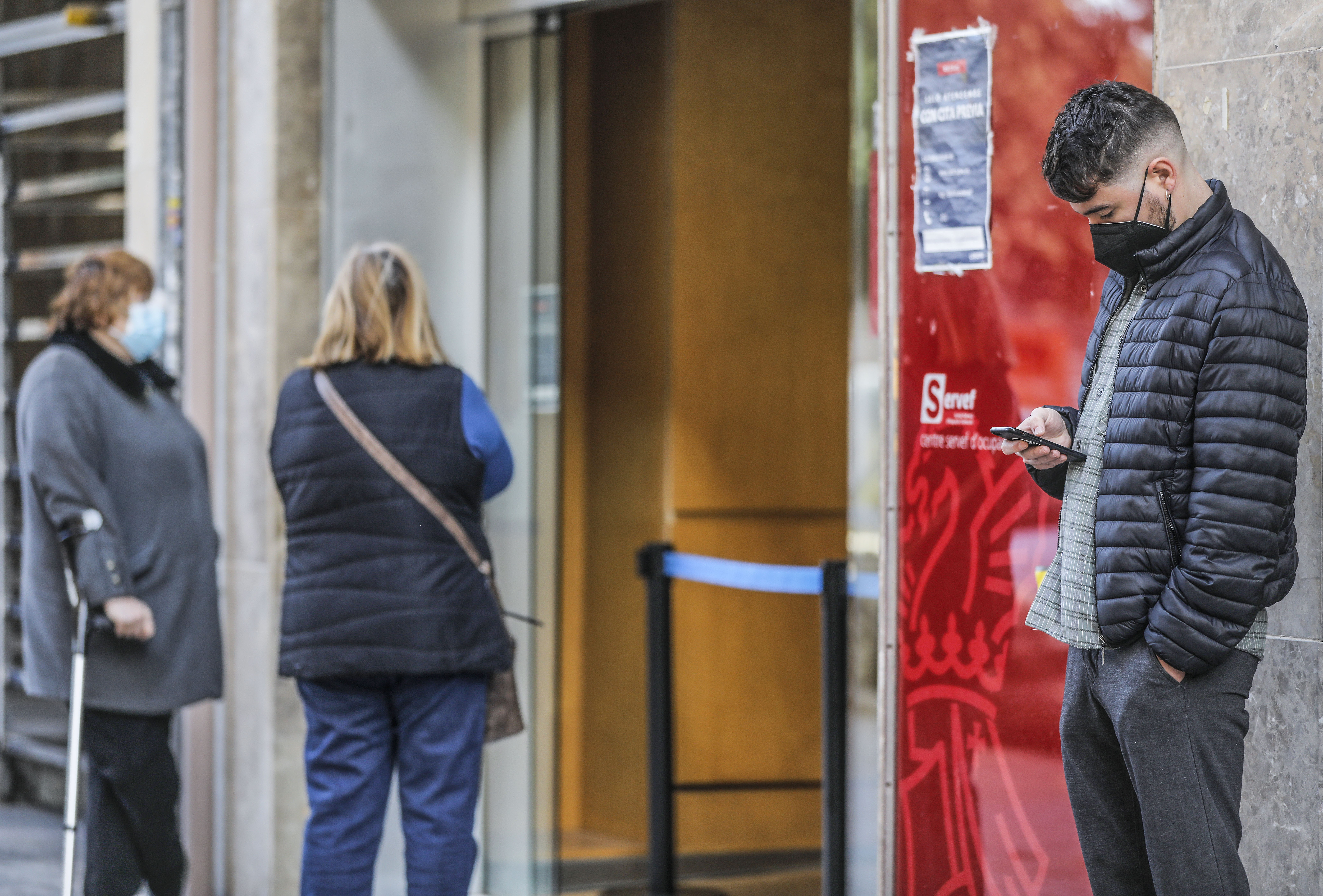 Un joven espera para entrar en una oficina del SEPE en Valencia. Foto: ROBER SOLSONA/EP - 