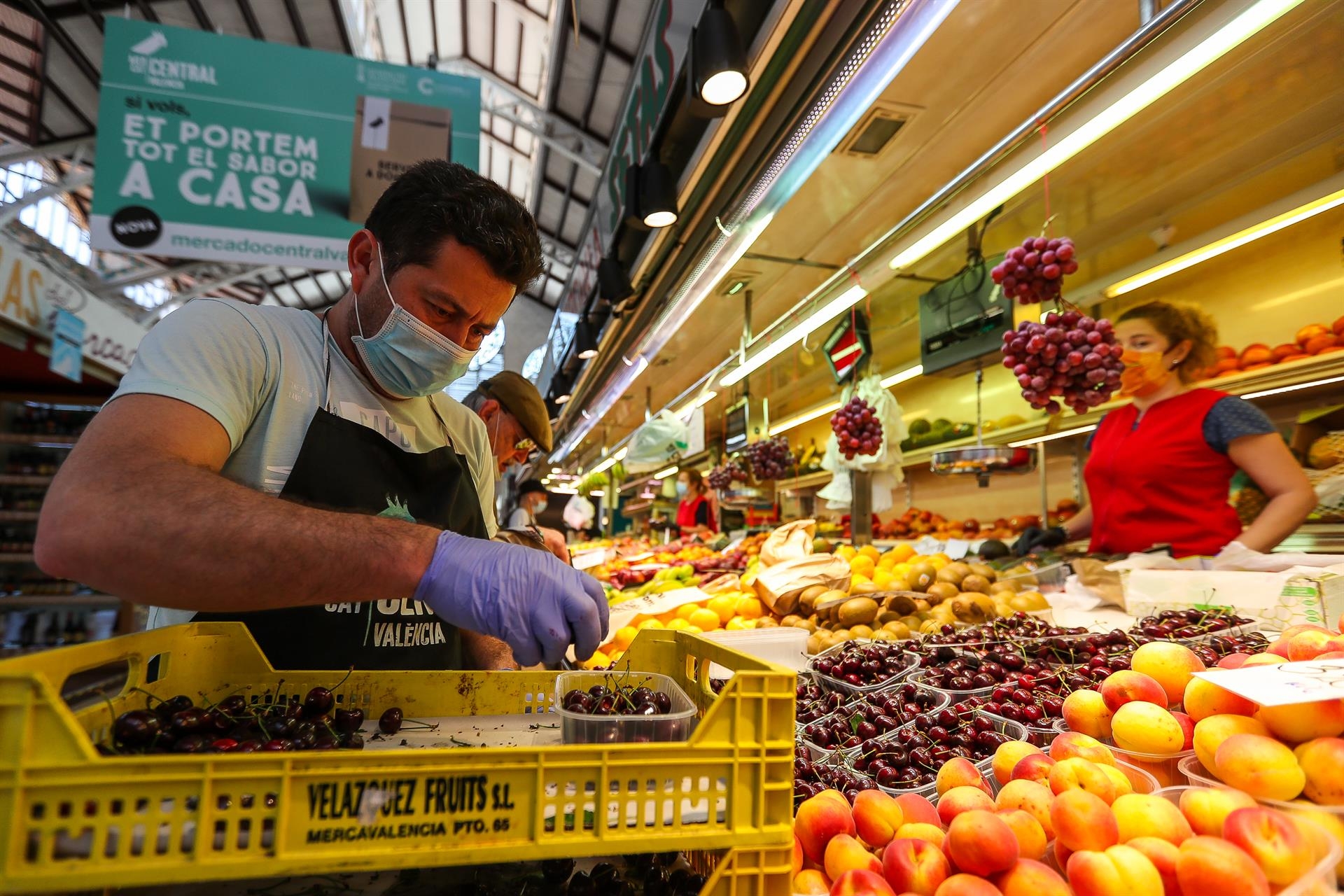 Un hombre trabaja colocando la fruta en una una frutería del Mercado Central de Valencia. Foto: IVÁN TERRÓN/EP - 