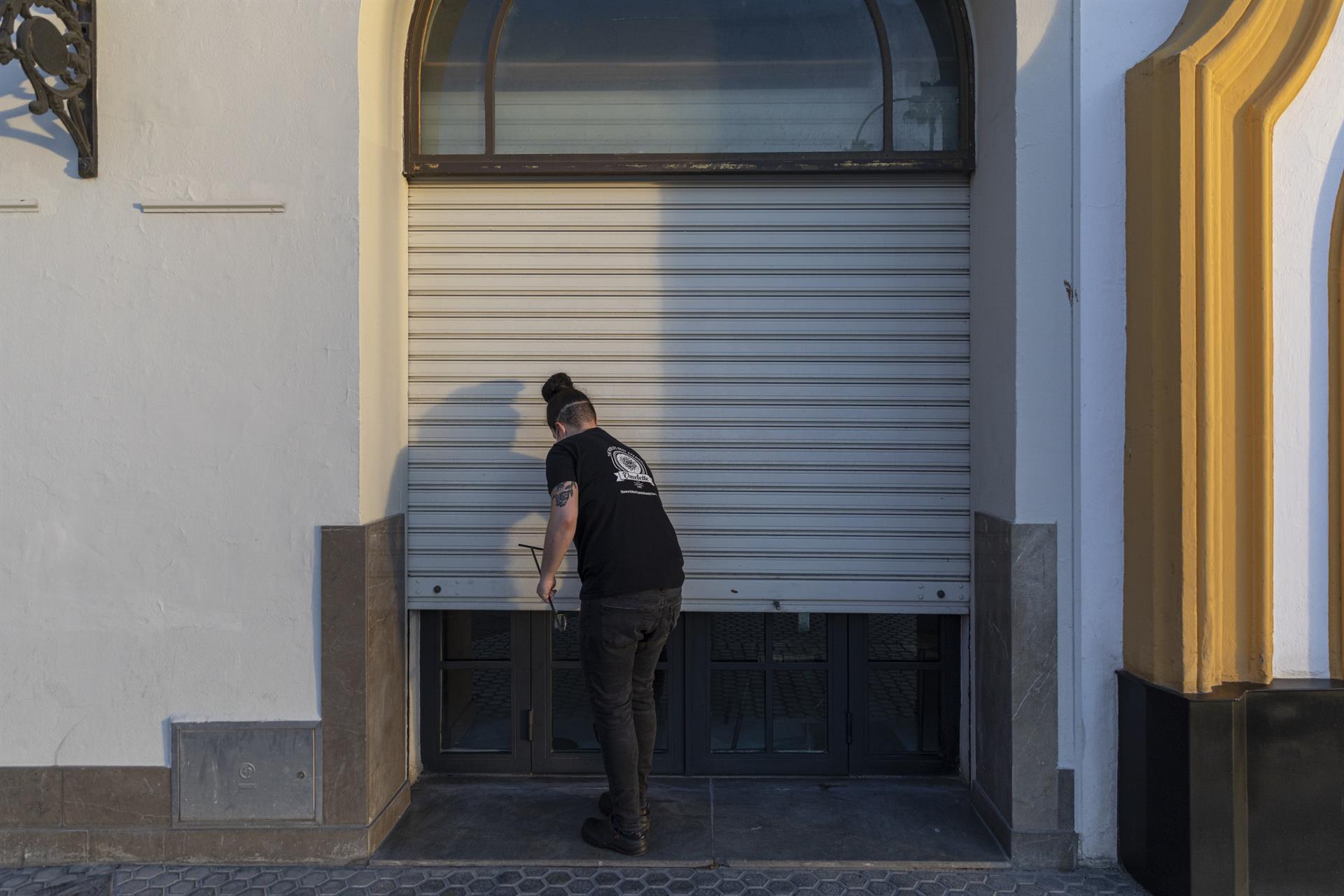 Un hostelero echa la persiana de su establecimiento. FOTO: EUROPA PRESS - 