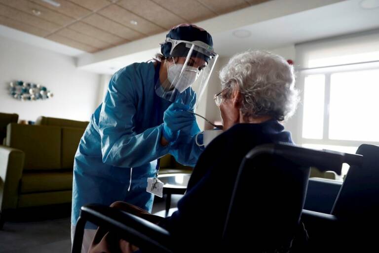  Una cuidadora ayuda a comer a una anciana en una residencia madrileña. Foto: EFE/Mariscal  - 