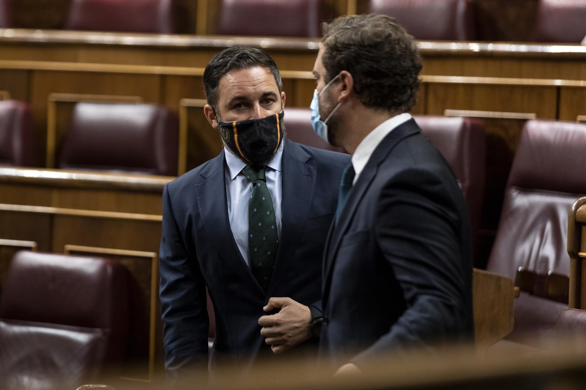 El presidente y el portavoz de Vox, Santiago Abascal e Iván Espinosa de los Monteros, charlan antes del inicio de una sesión plenaria. Foto: POOL  - 