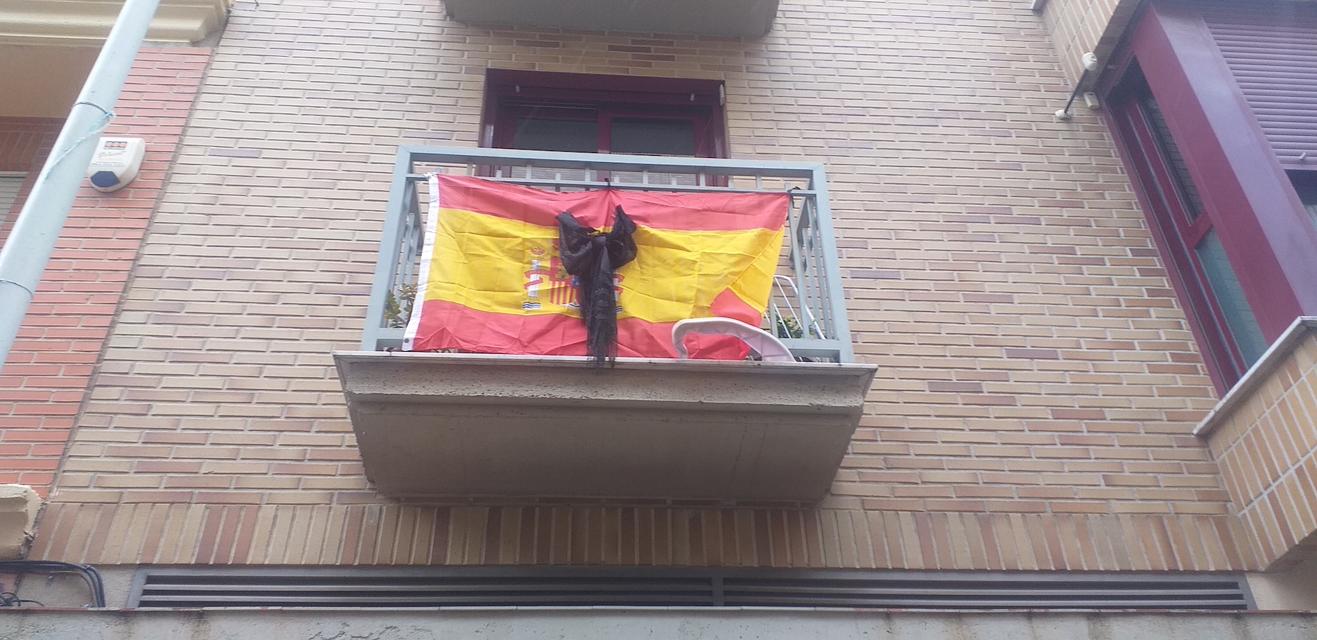 Una bandera española con un crespón en recuerdo de los muertos por coronavirus. - 