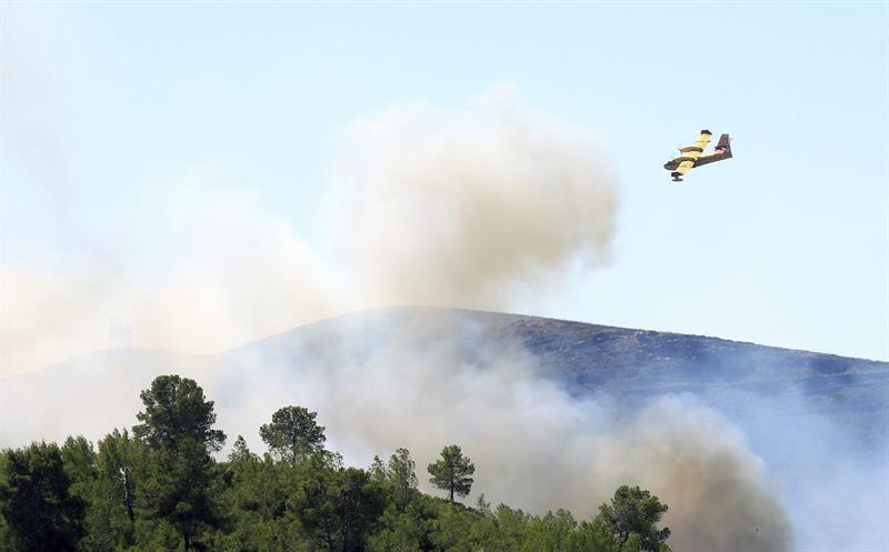 Un hidroavión sofoca las llamas en la zona de Gàtova. FOTO: DOMENECH CASTELLÓ / EFE - 