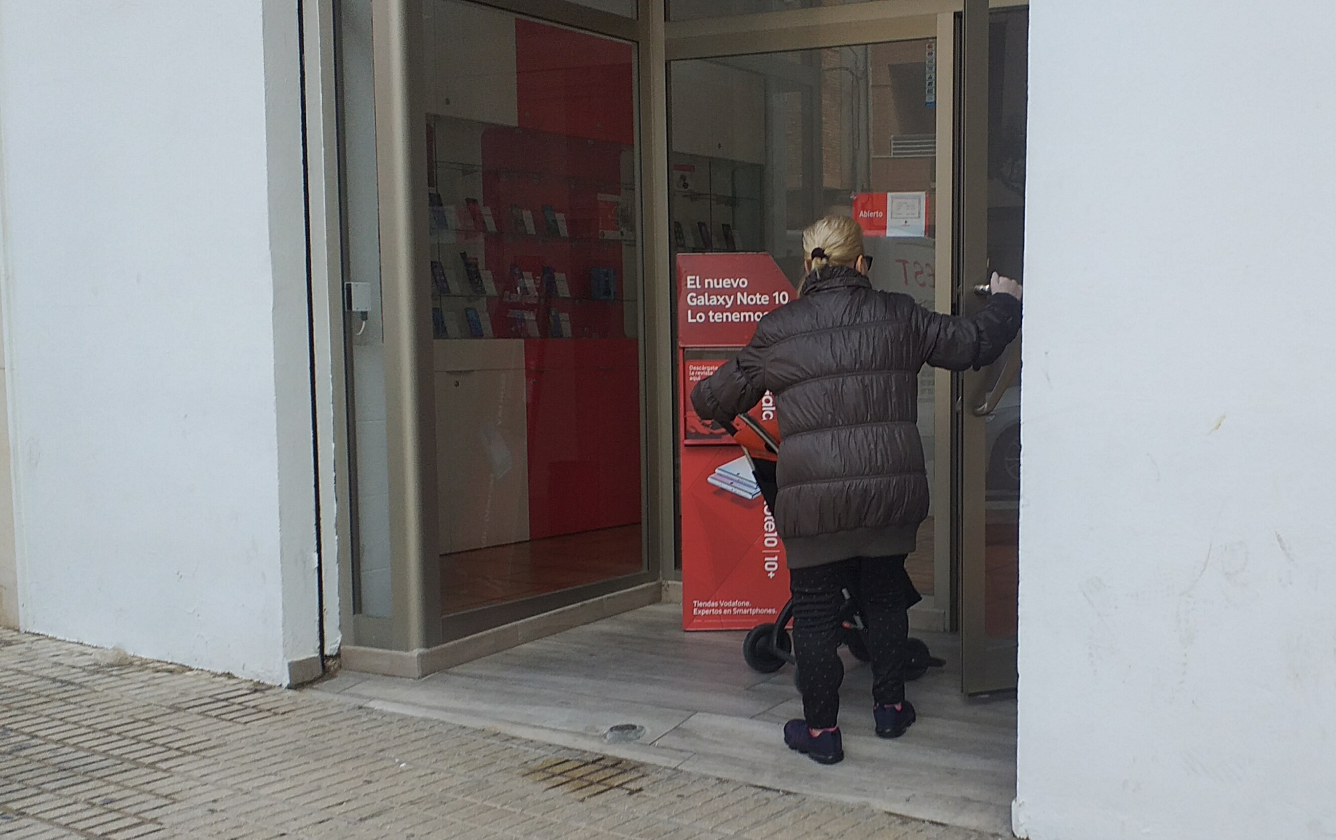 Una anciana entra, ayer, en una tienda con un carro de la compra.  - 