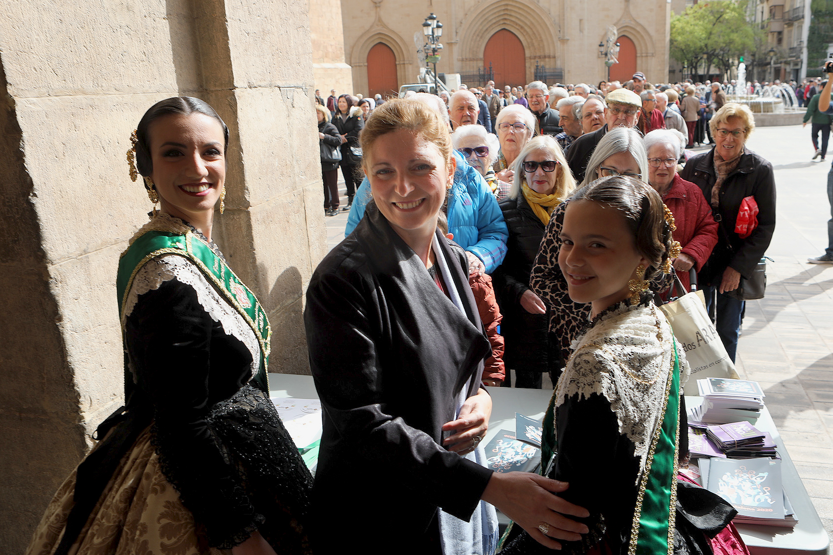 Las reinas de las fiestas y Amparo Marco, en el reparto de 'llibrets' realizado este martes en la plaza Mayor. - 
