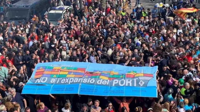 La Comissió Ciutat-Port exhibe durante la mascletà una pancarta contra la ampliación del Puerto de Valencia