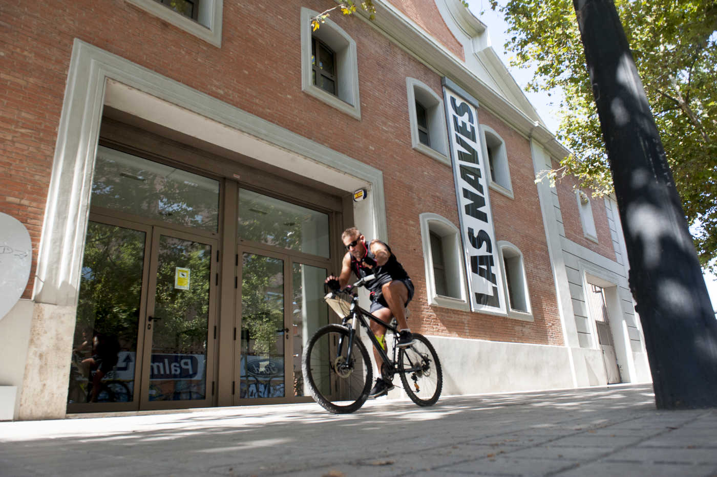 Un ciclista pasa junto a Las Naves de Juan Verdegur. Foto: KIKE TABERNER - 