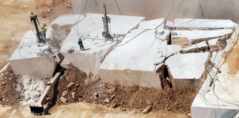 Empleados de Levantina sobre un bloque de mármol en la cantera del Monte Coto. Foto: RAFA MOLINA - 