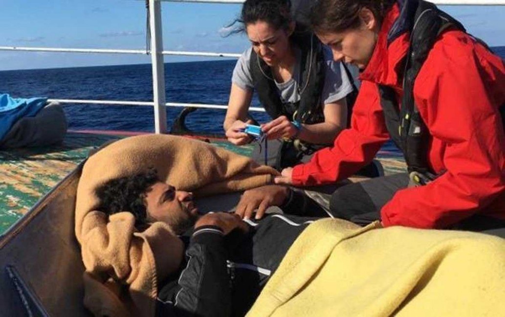 Los voluntarios de la ONG Open Arms atienden a uno de los inmigrantes al alcanzar al barco pesquero, el pasado viernes. Foto: EFE / OPEN ARMS - 