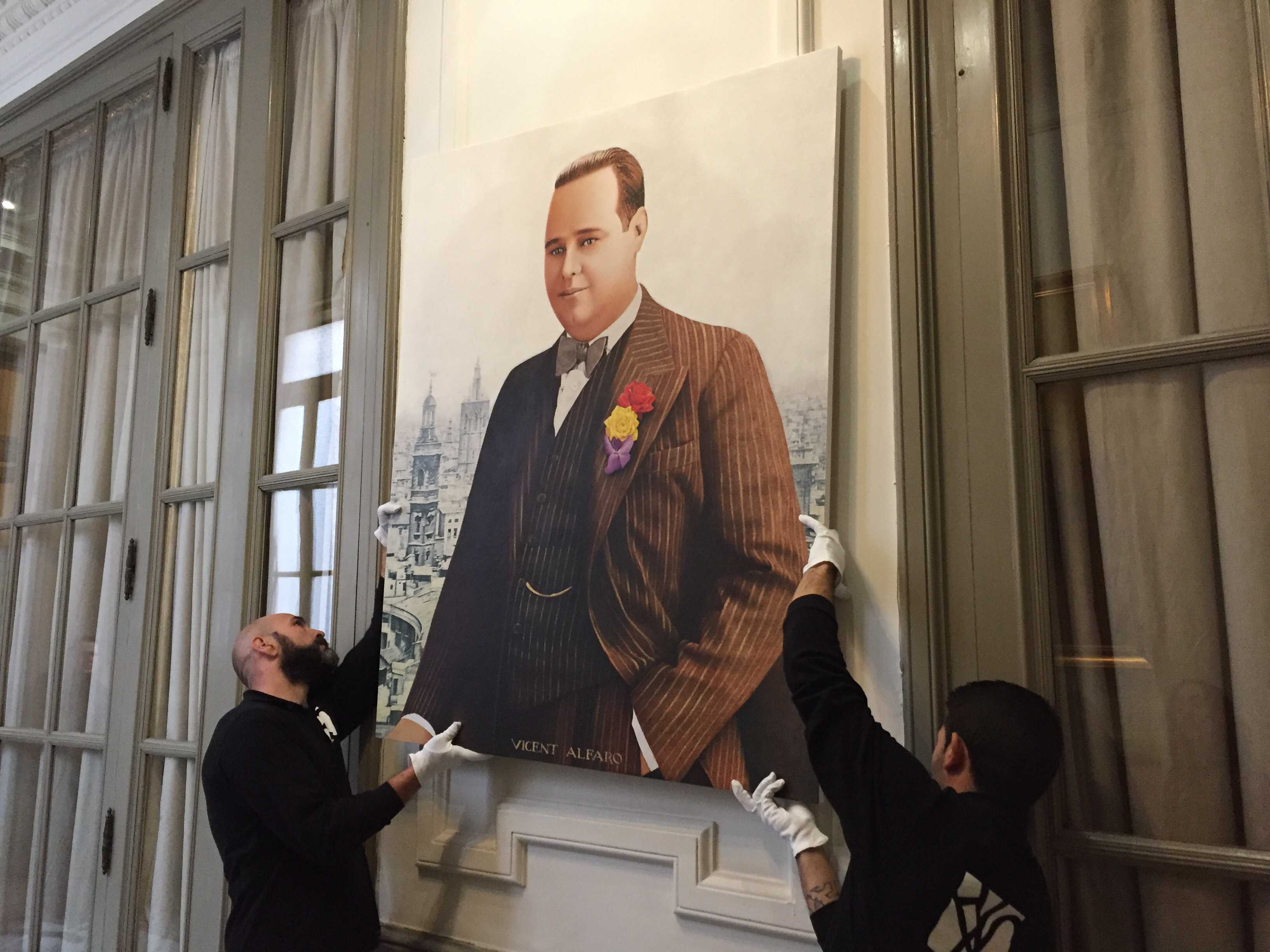 Momento en el que dos operarios disponen el cuadro de Vicente Alfaro en la galería de alcaldes. - 